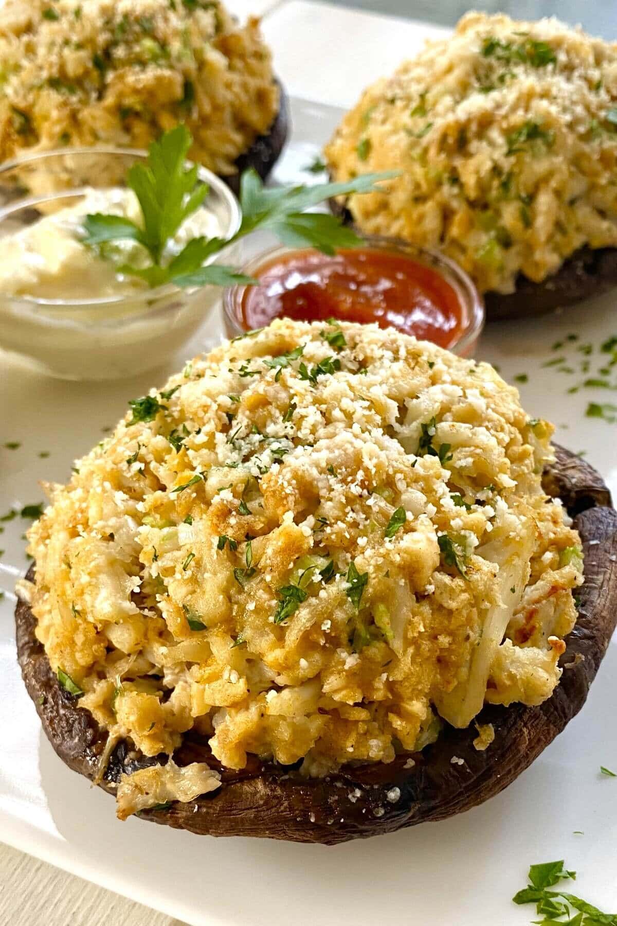 baked crab cake stuffed portobello mushroom on with tartar and cocktail sauces.