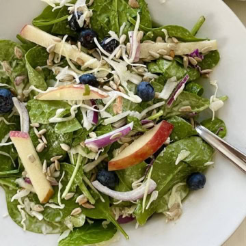 a salad with spinach and blueberries