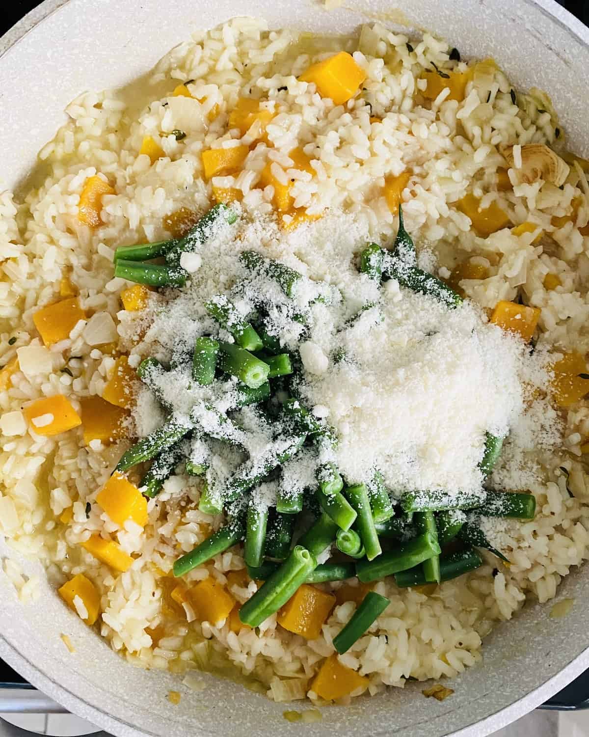 adding green beans and Parmesan cheese to easy rice recipe