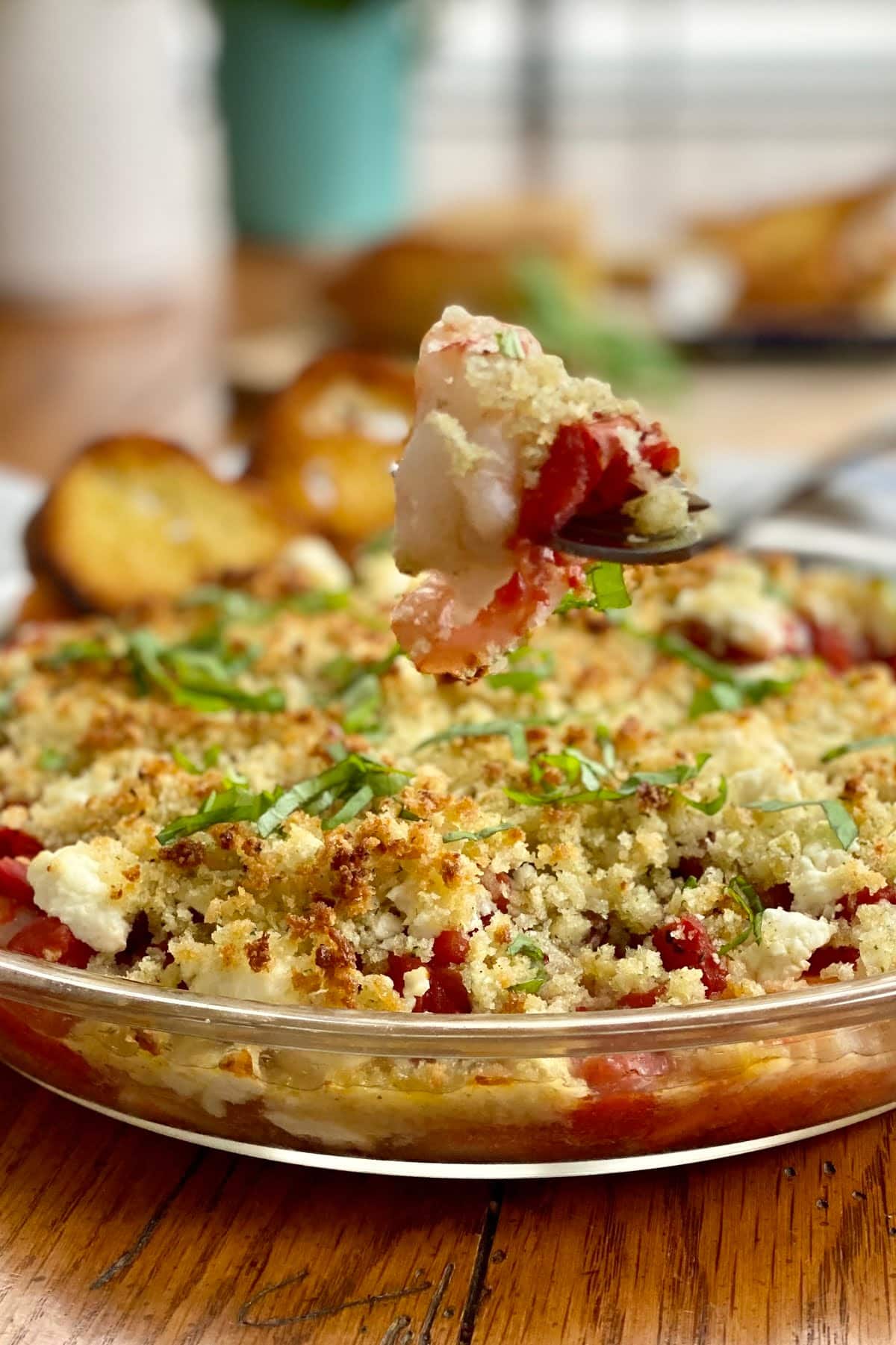 a baked shrimp on a fork with feta and tomatoes