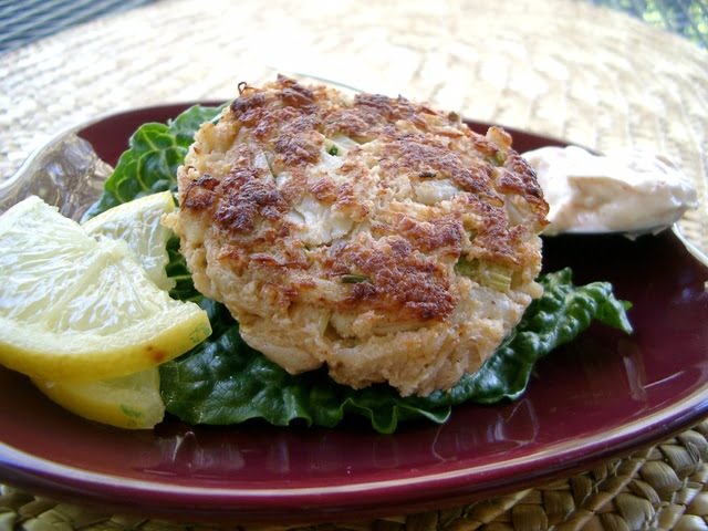 Jumbo lump crab cakes with chipotle on a plate with lettuce.