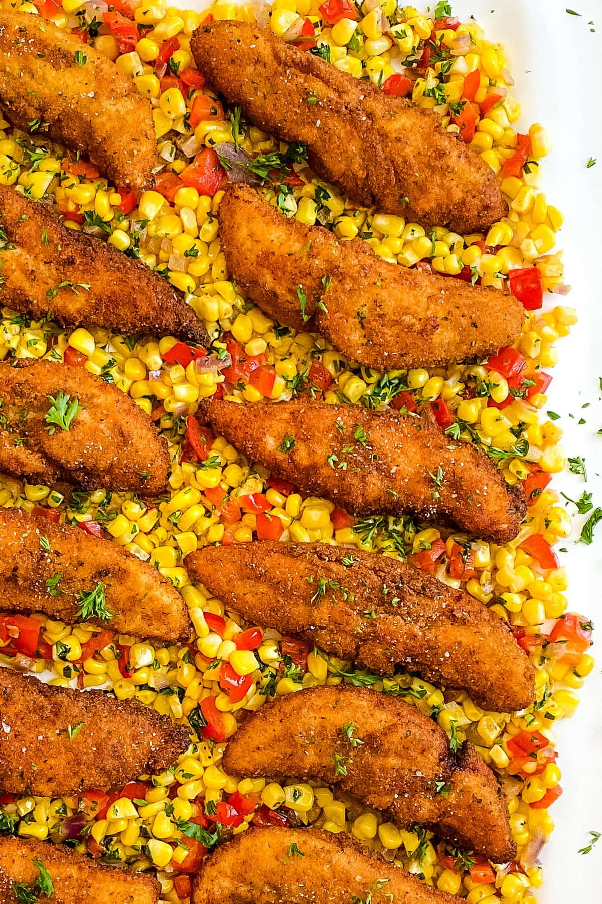 platter with pan fried chicken tenders and corn sauté