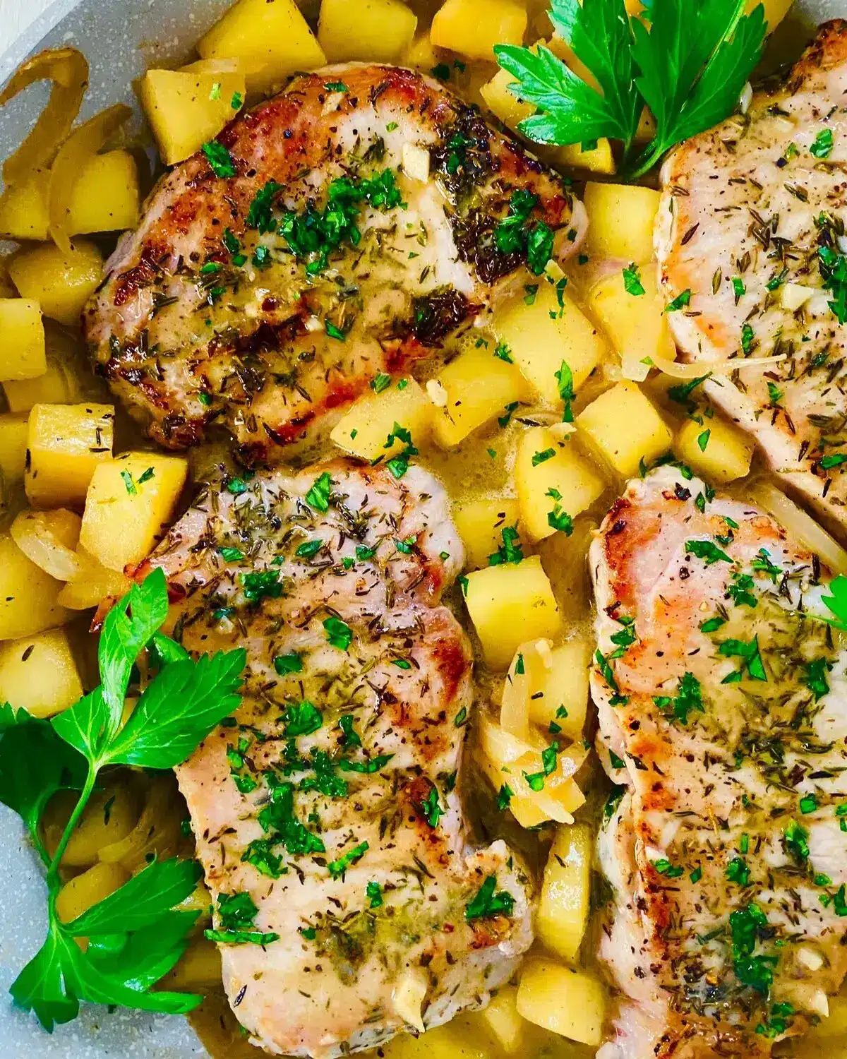 a pan with pork chops and apples.