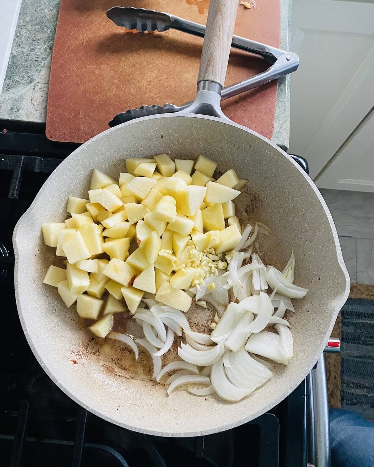 apples, onions and garlic in a pan.