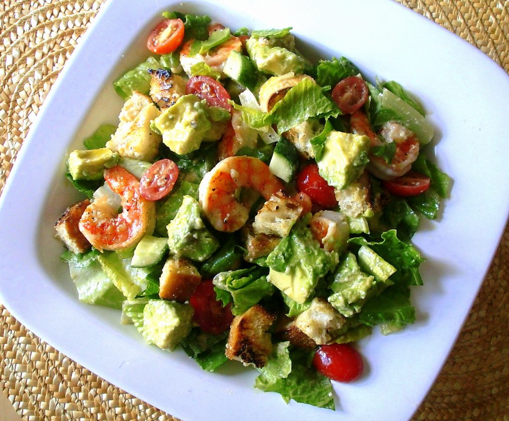 Caesar salad with shrimp and cherry tomatoes.