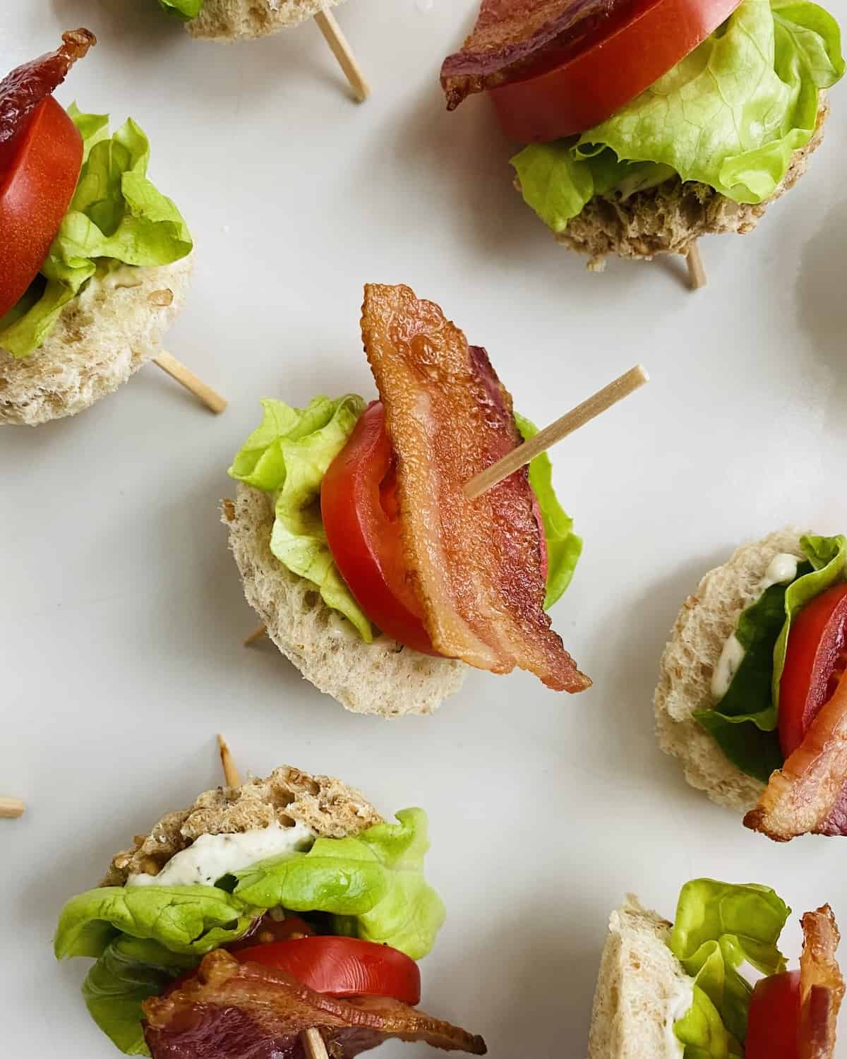 A toothpick with bacon, lettuce and tomato snack.
