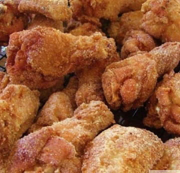 Fried chicken wings cooling on a wire rack.