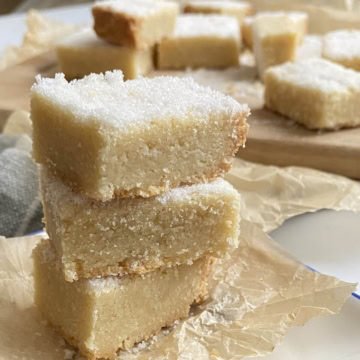 Three sugared shortbread cookies in a stack.