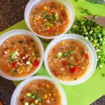 4 take out containers with vegetable barley soup.