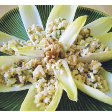 Endive leaves stuffed with walnuts and parmesan on a green plate.