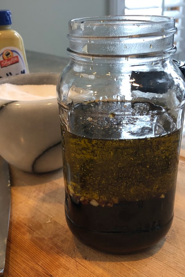 A mason jar filled with ingredients for balsamic steak marinade.