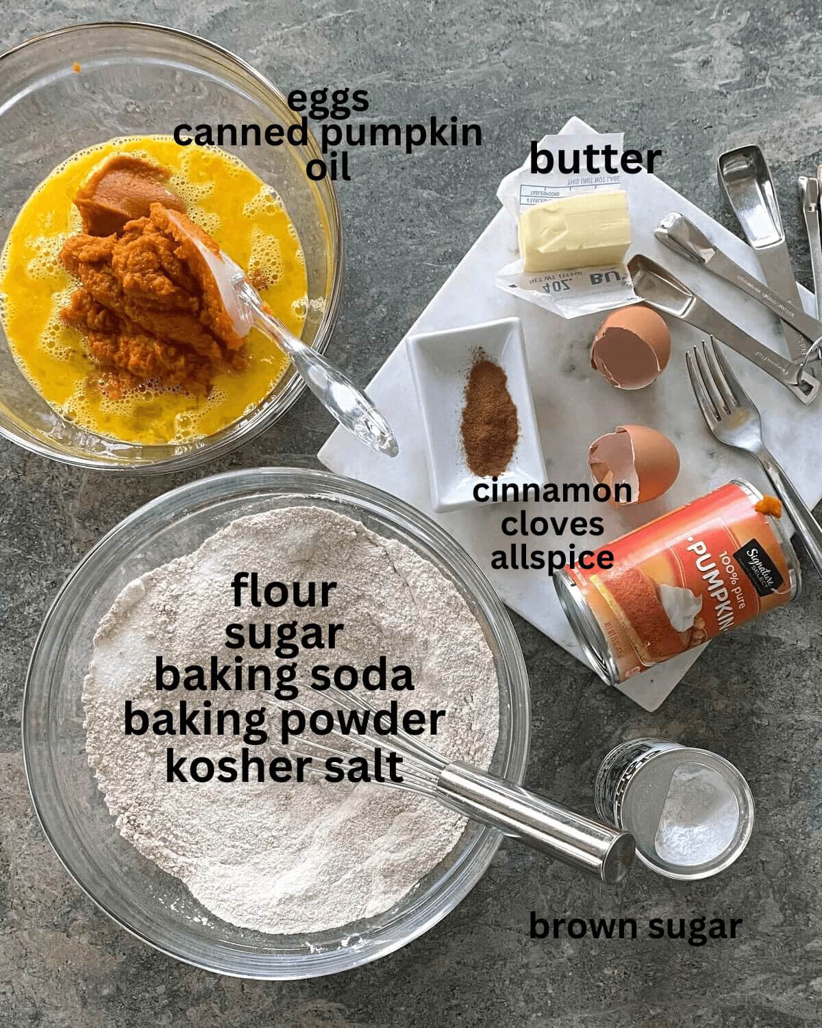 Flour, sugar, eggs, canned pumpkin, cinnamon, butter, cloves, and allspice on a counter.