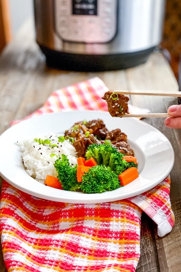 Asian beef stew with Instant Pot in background.