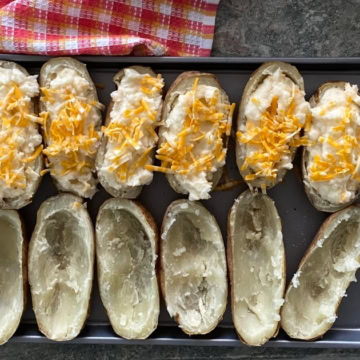 sheet pan of stuffed potatoes with cheddar cheese