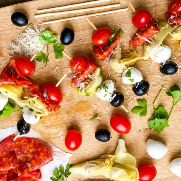 bamboo sticks with tomato, mozzarella, artichokes, salami and olives