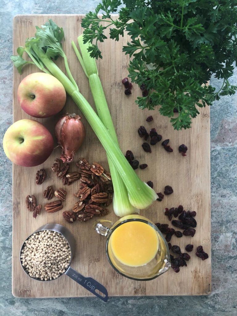 ingredients for recipe including couscous, orange juice, celery, apples, craisins and pecans