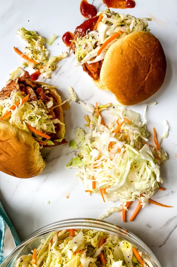 Cole slaw and 2 barbecue pork tenderloin sliders.
