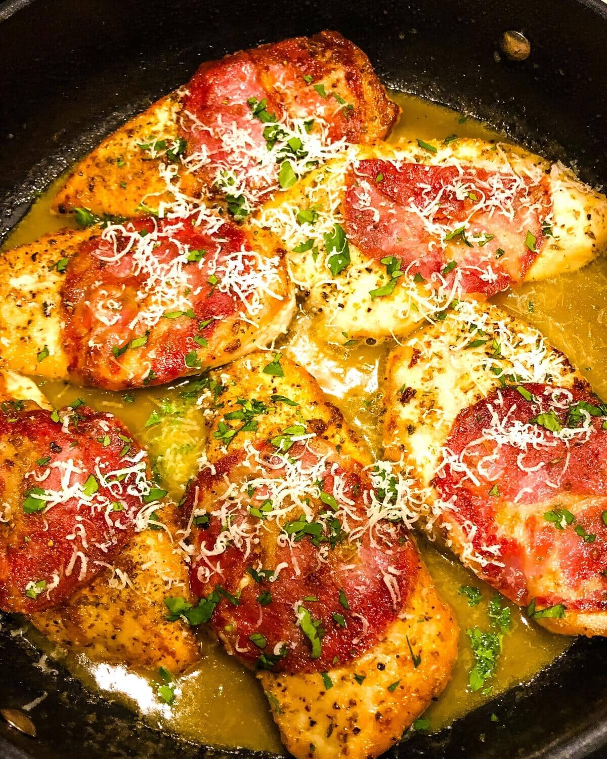 capicola chicken in white wine sauce in a sauté pan.