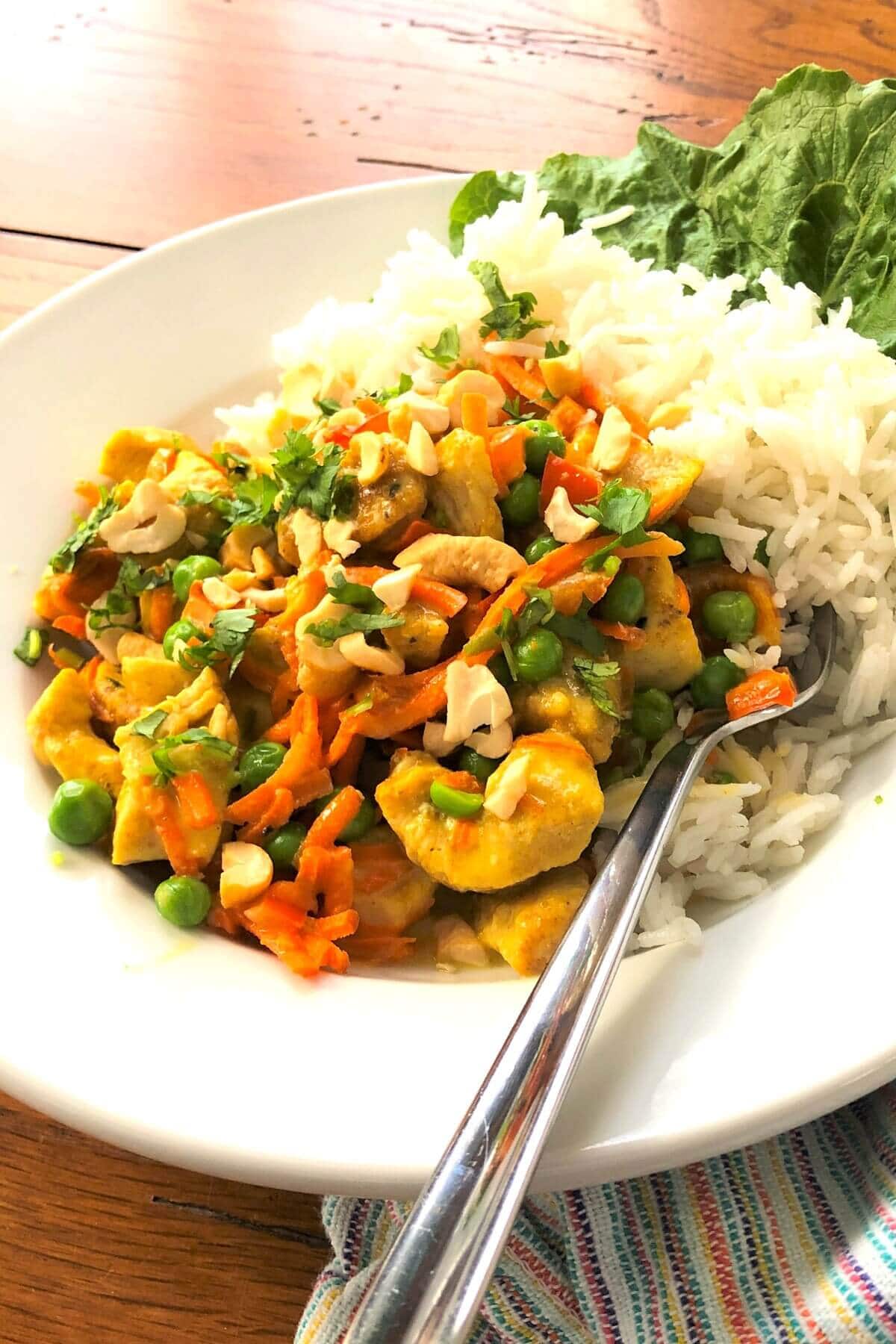 Thai chicken over jasmine rice in a bowl.