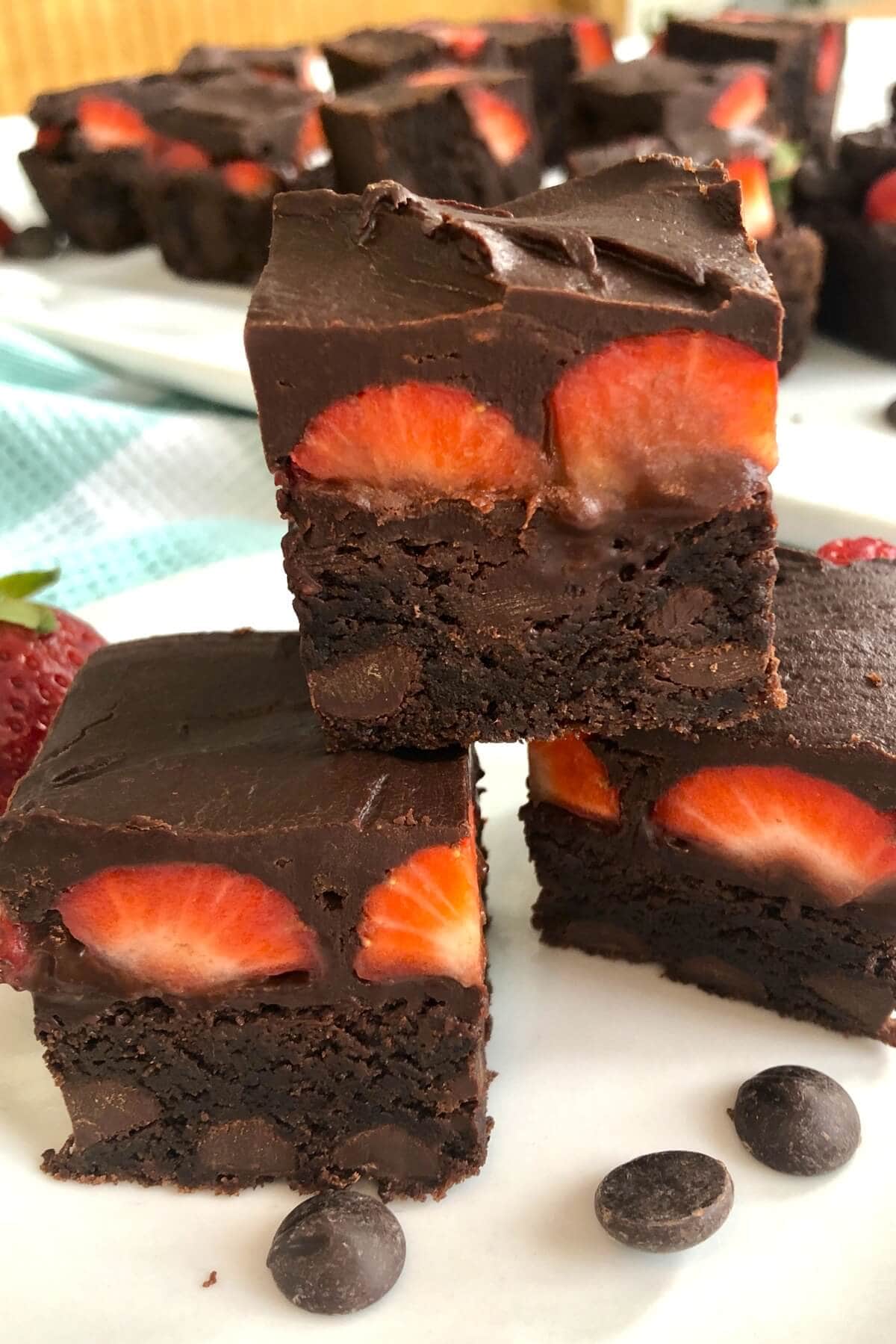 3 brownies with strawberries in a stack.