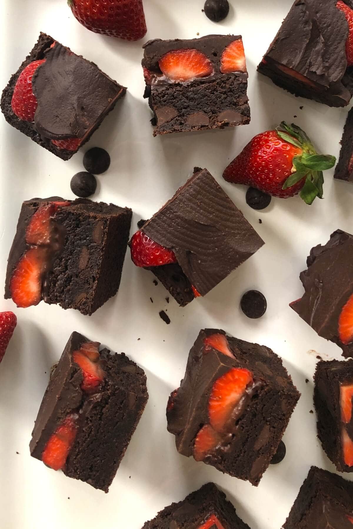 Small brownies with fresh strawberries and chocolate icing.