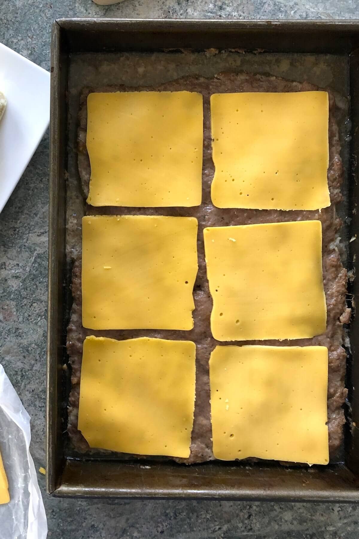 cheese on top of large burger patty for siders.