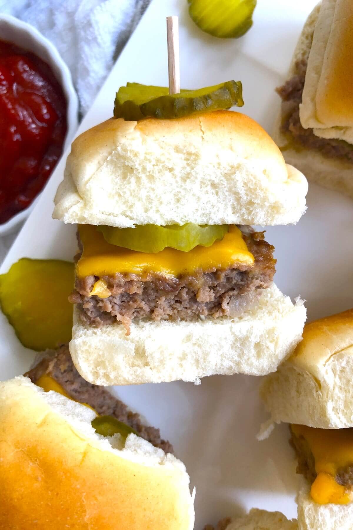 single cheeseburger slider with a dill pickle chip.