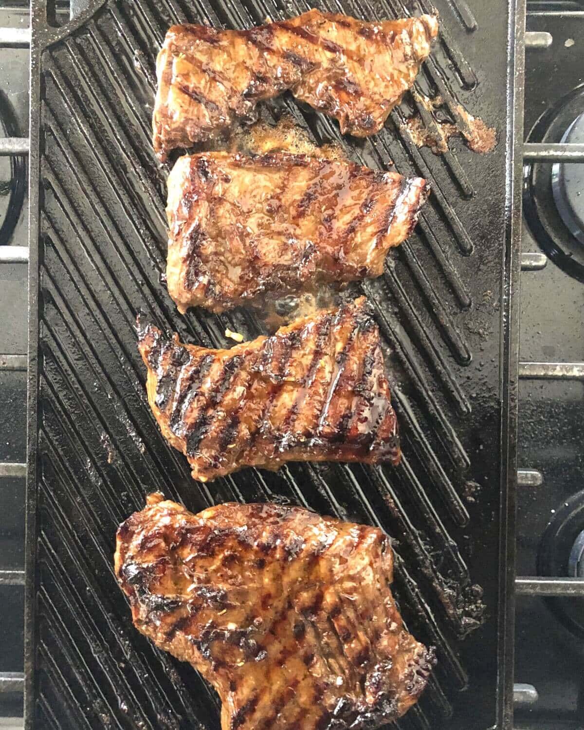 A grill pan that's grilling skirt steak.