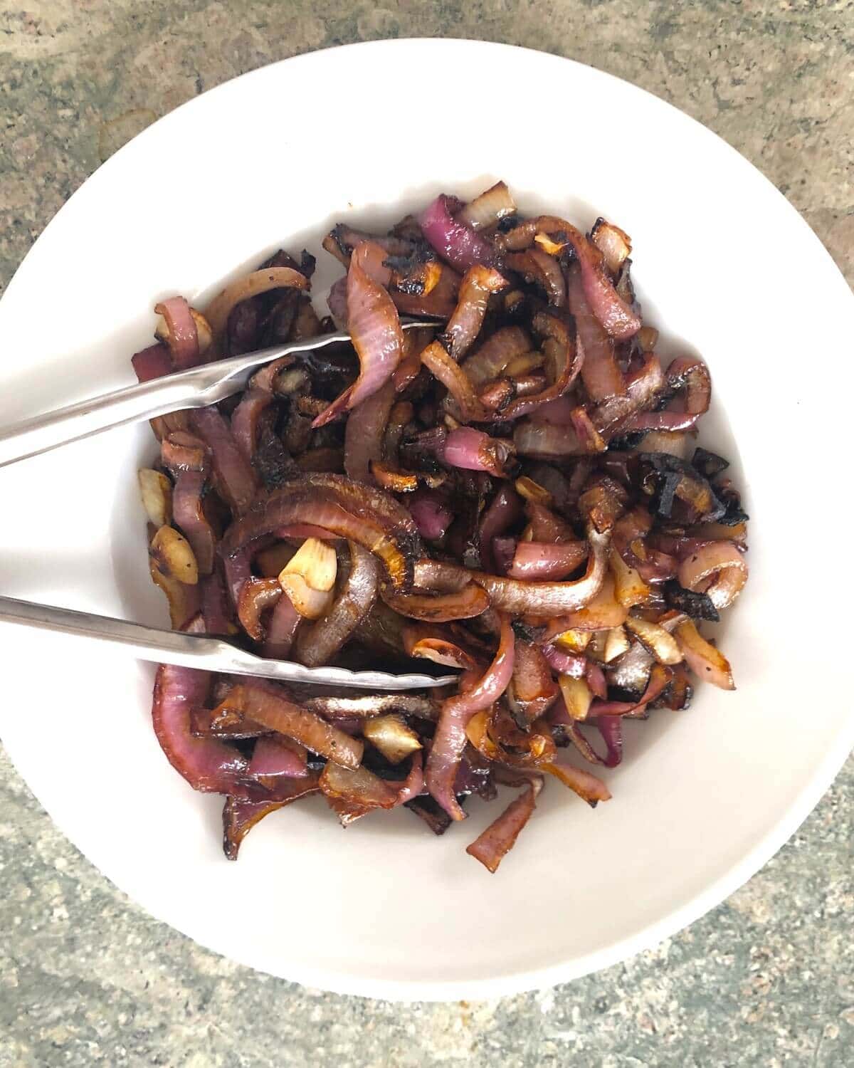 A bowl with roasted red onions.