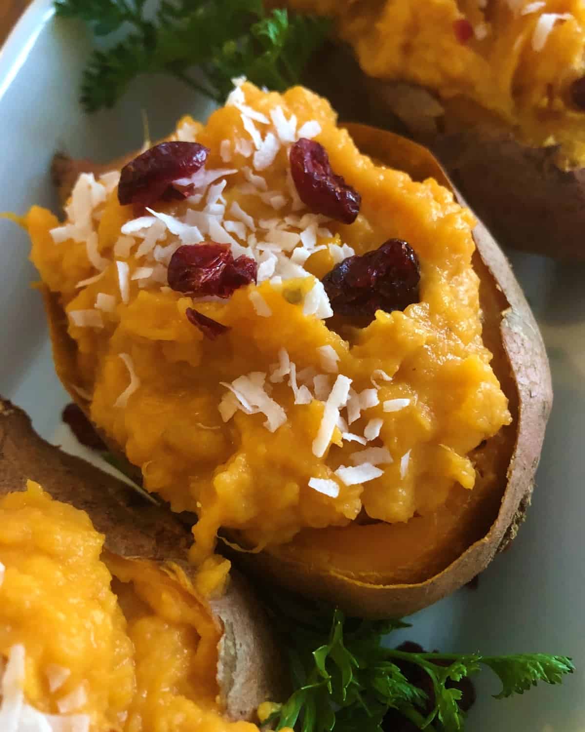 baked sweet potatoes stuffed topped with coconut and dried cranberries