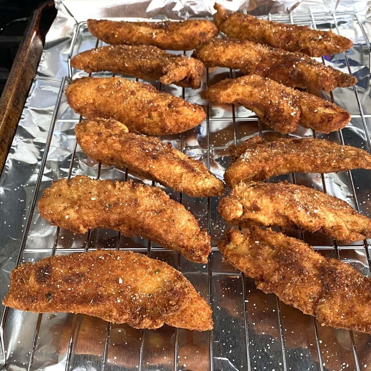 fried buttermilk chicken tenders on a baking rack.