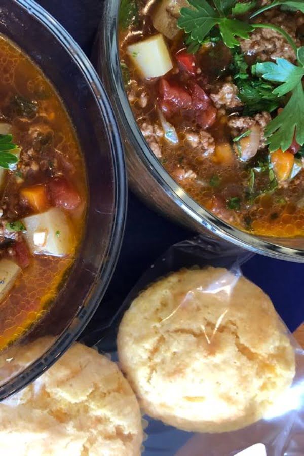 2 bowls of hamburger soup with cornbread muffins