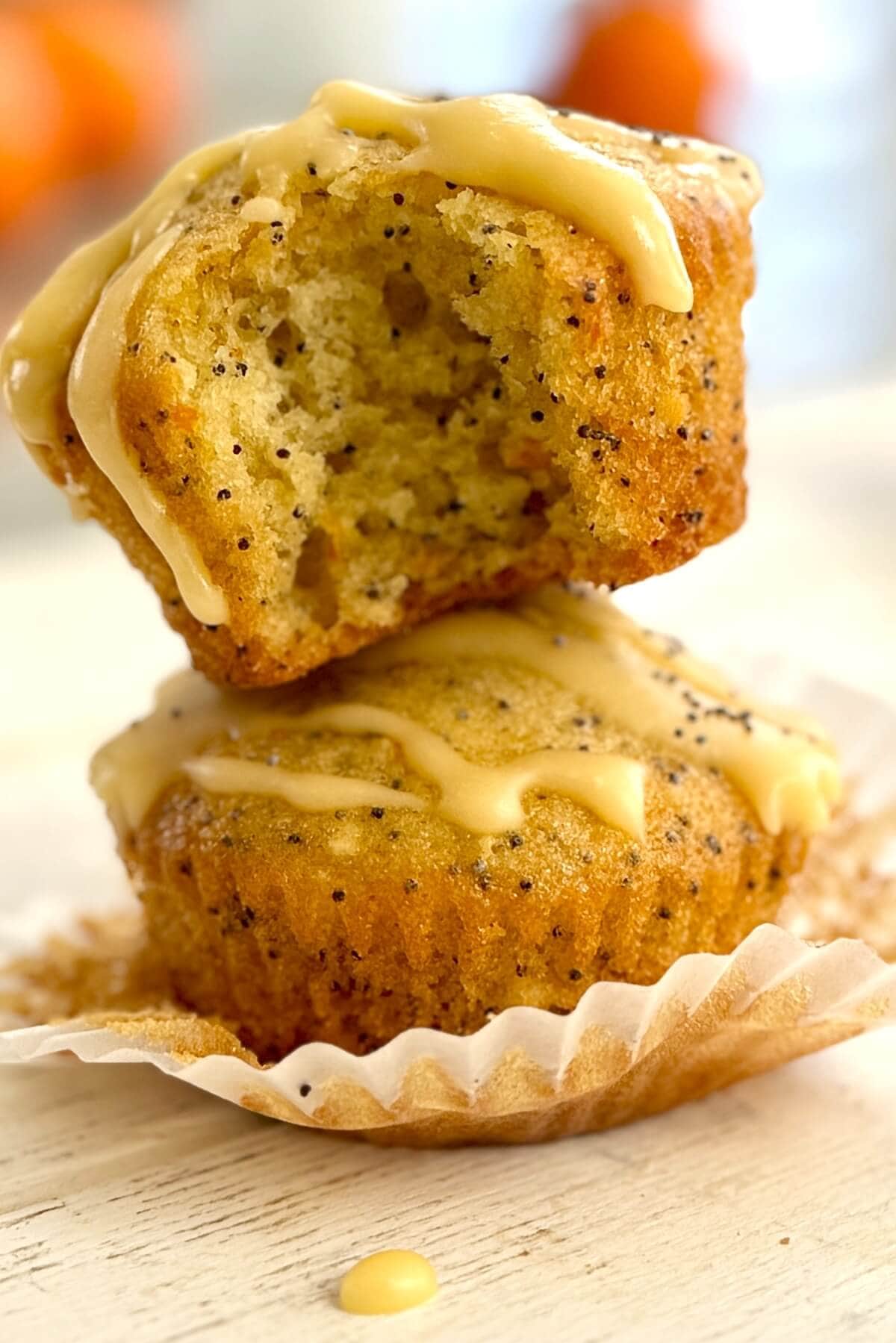 2 orange poppy seed muffins in a stack.