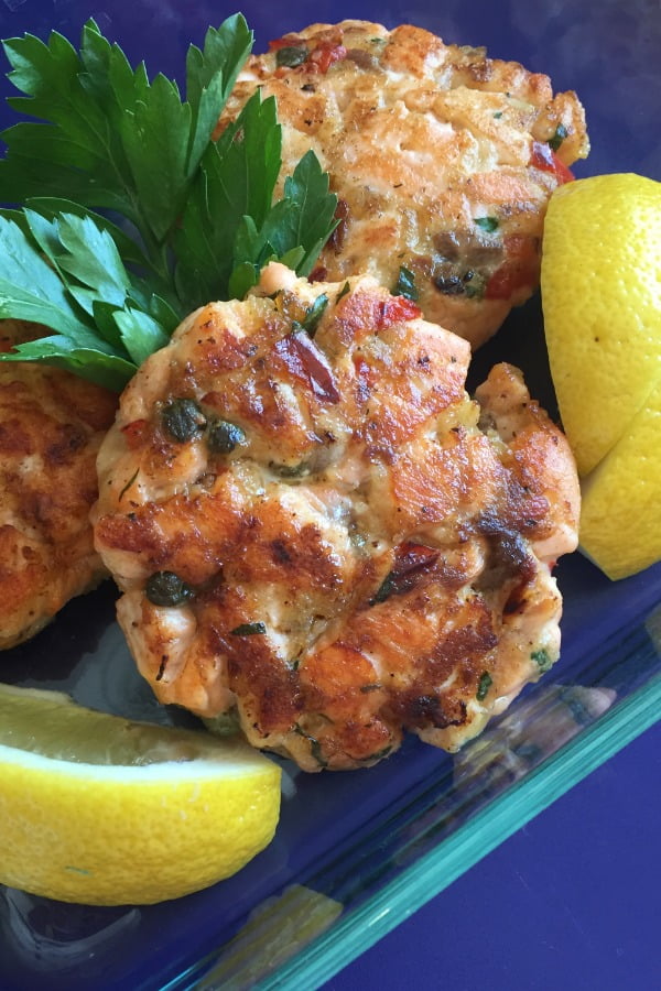 sauteed salmon cakes with lemon wedges