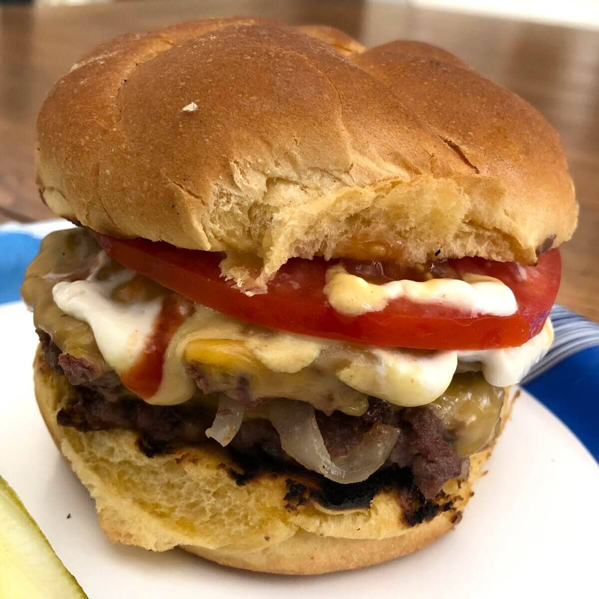 smash burger with tomato and cheese.
