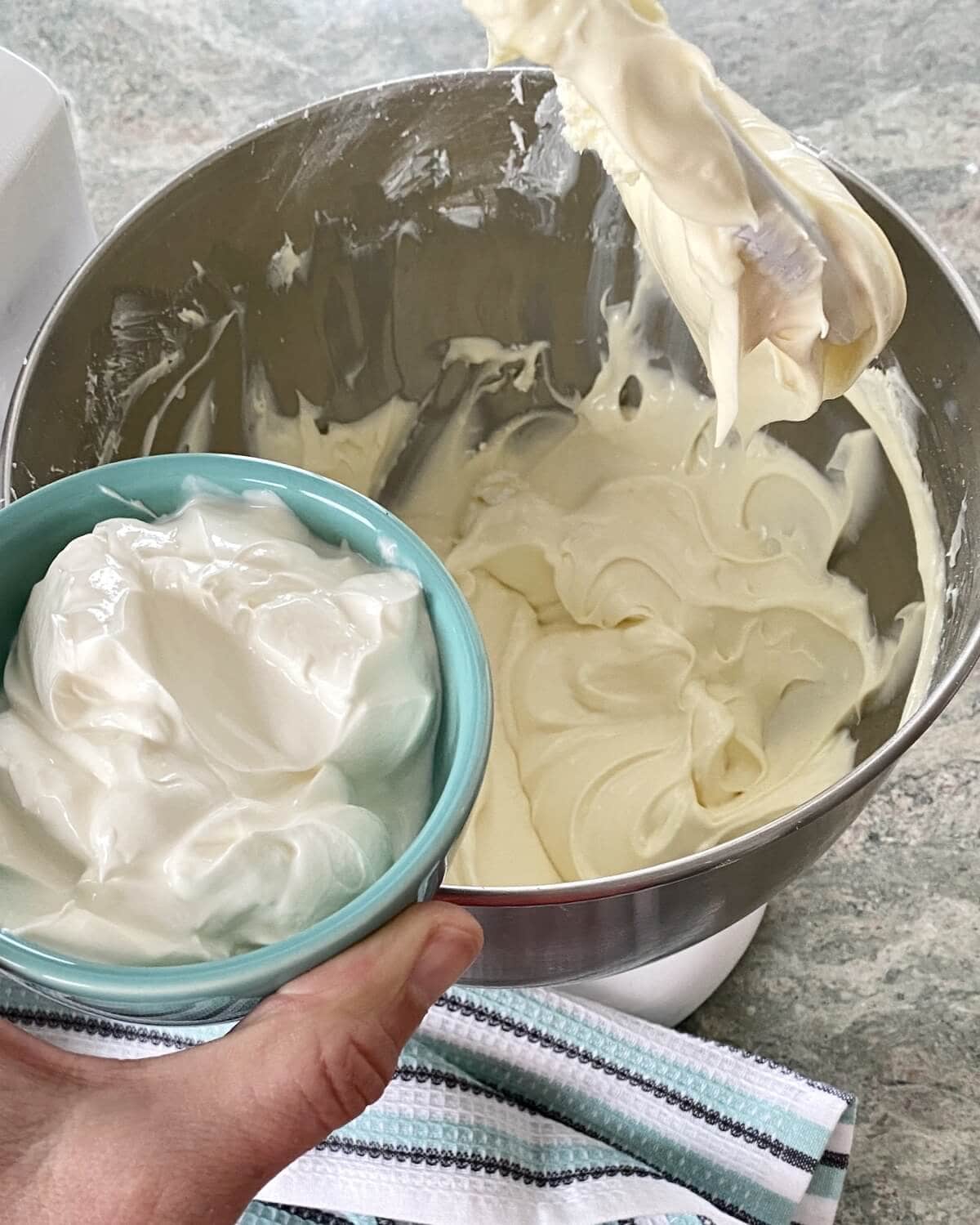 Adding sour cream to cheesecake batter.