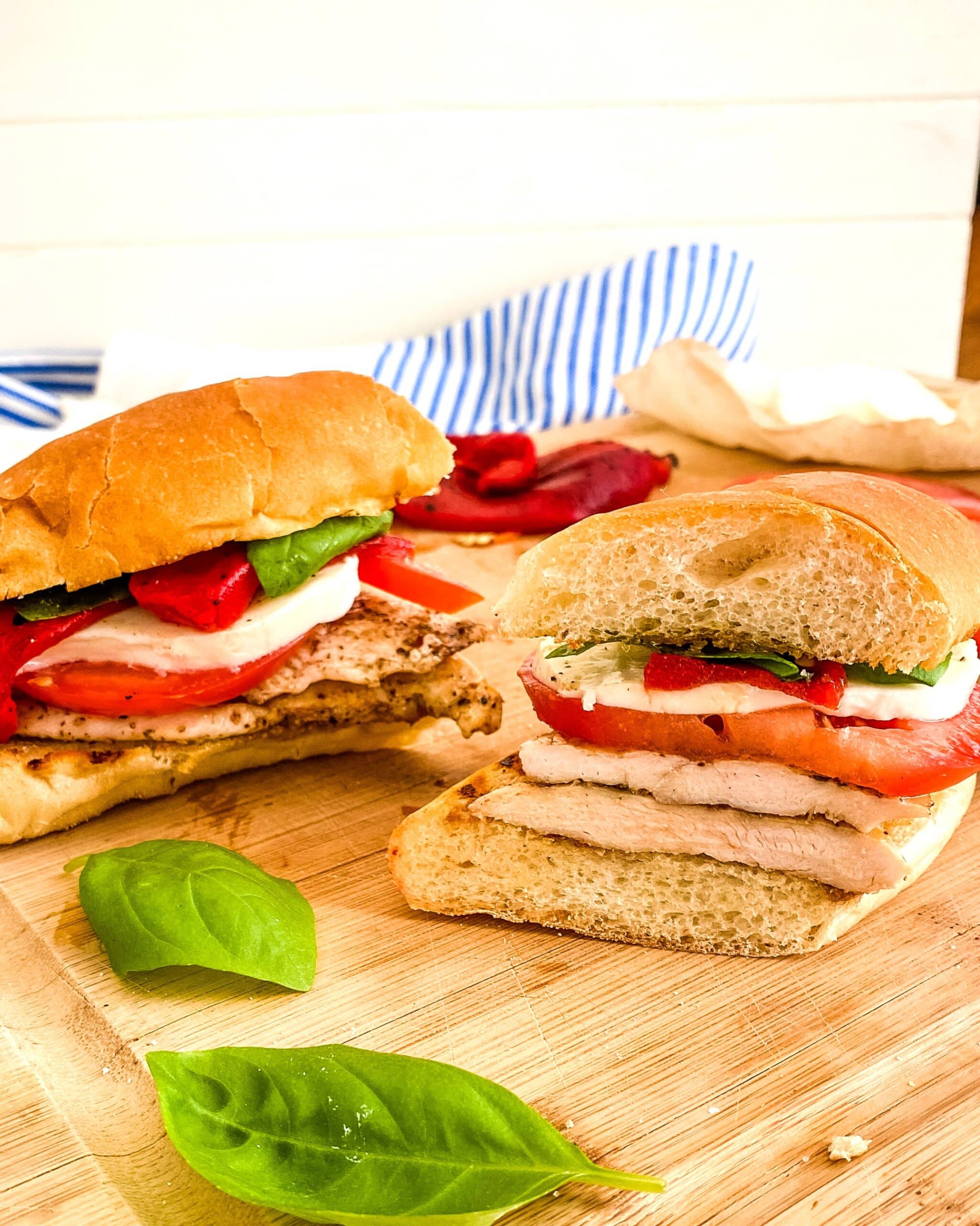 A tomato mozzarella and chicken sandwich on a bun.