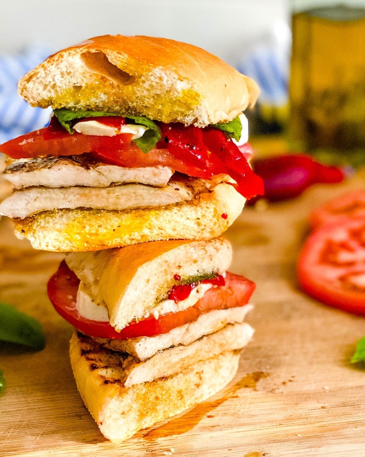 A chicken caprese sandwich cut in half.