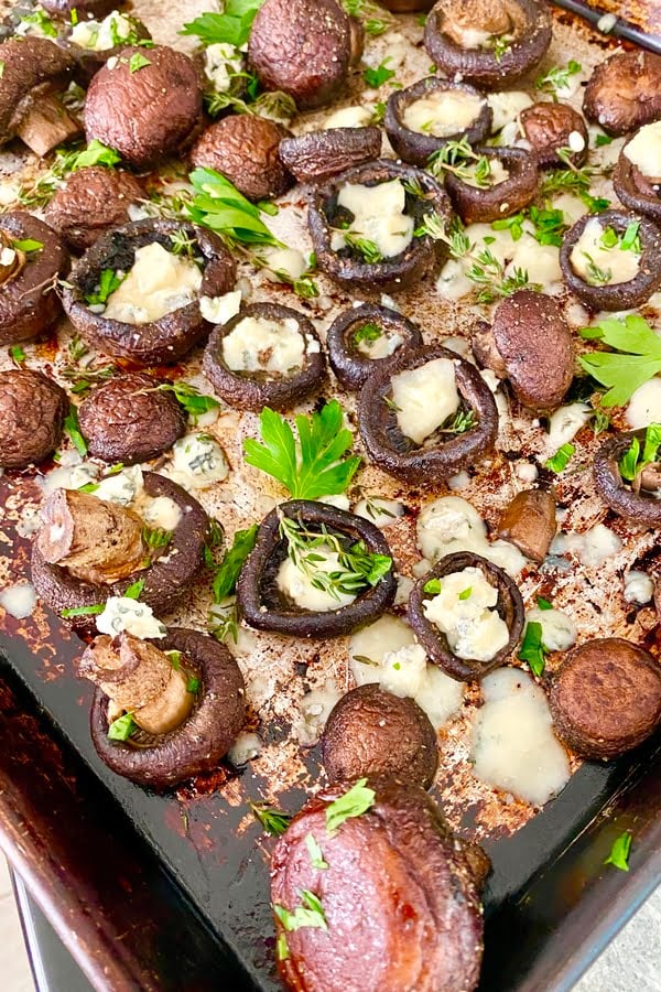 baked mushrooms with herbs on a baking sheet