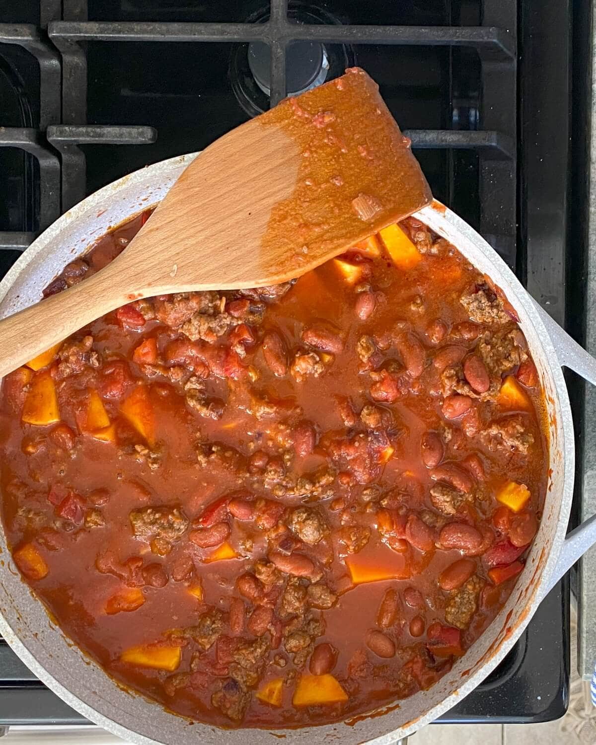 Chili simmering on the stove in a large pot.