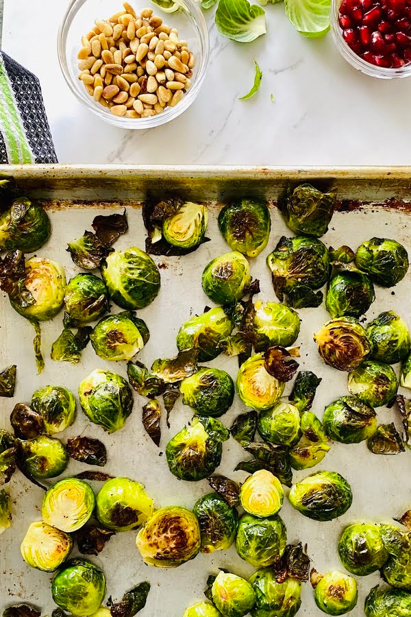 roasted Brussels sprouts on a baking sheet with honey