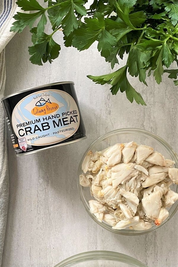 can of crab meat and a bowl of crab meat.