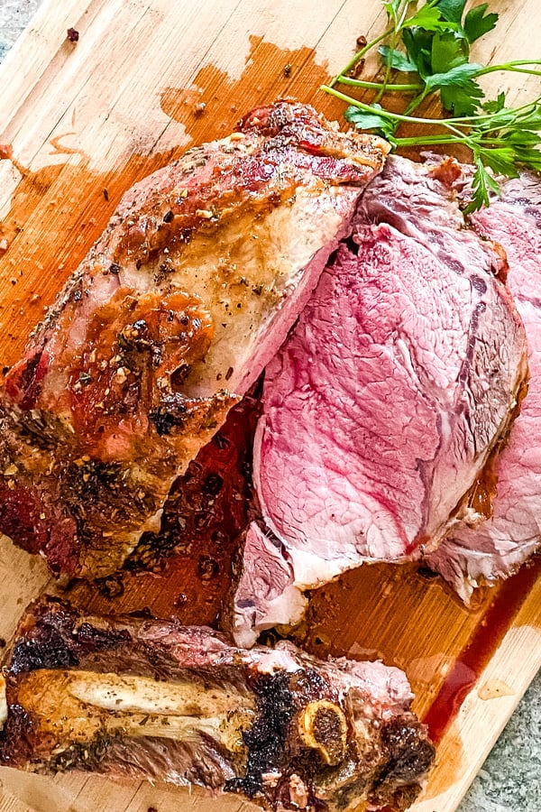 sliced slow roasted prime rib on a cutting board.