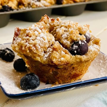 a powdered sugar topped French toast muffin with blueberries