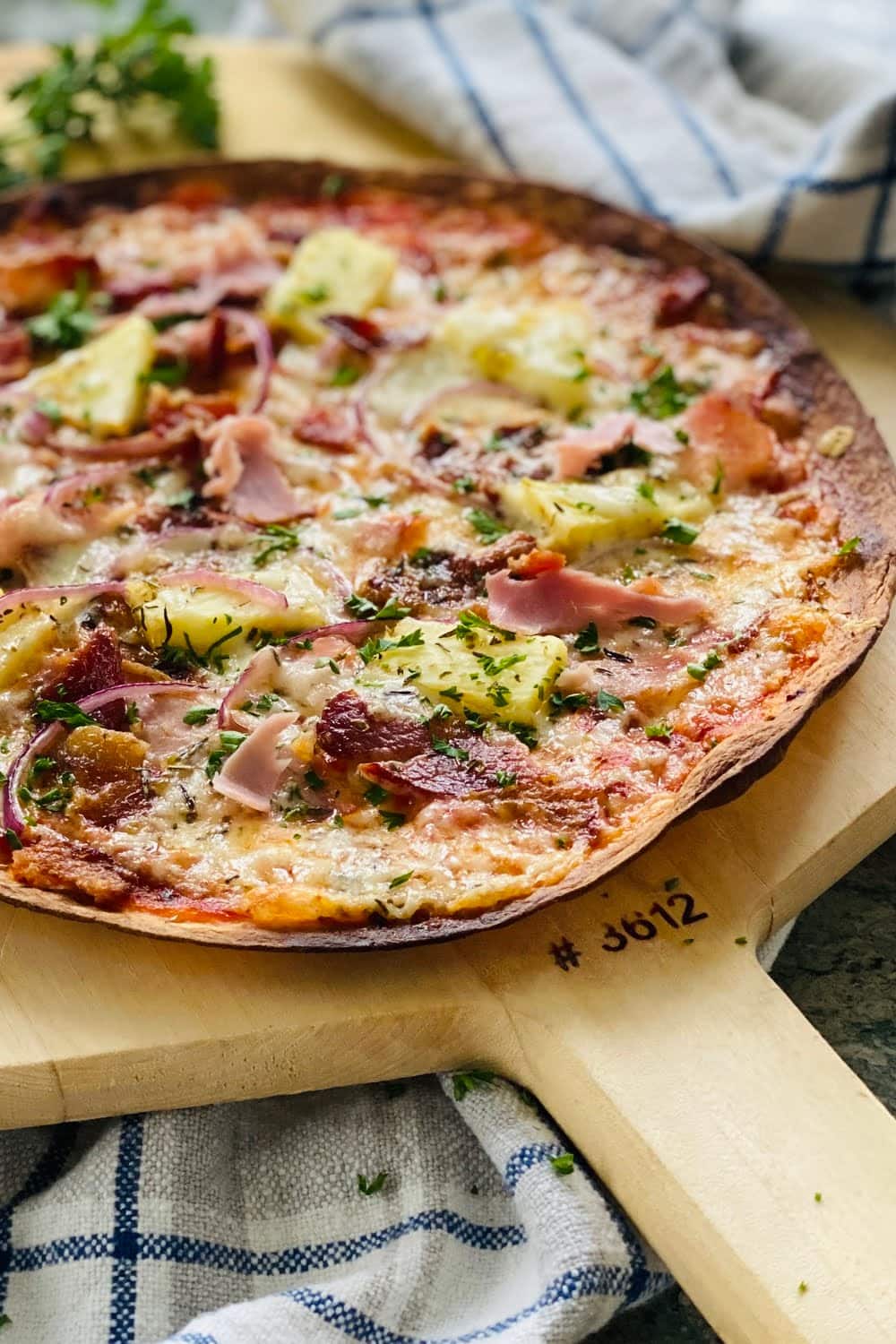 pizza made on a tortilla with ham and pineapple.