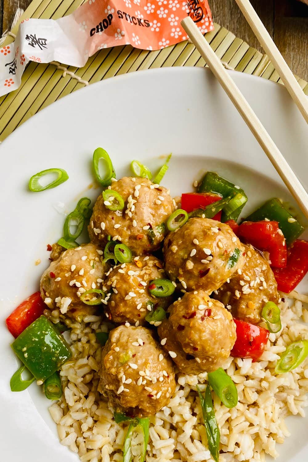bowl of teriyaki turkey meatballs with brown rice and chopsticks
