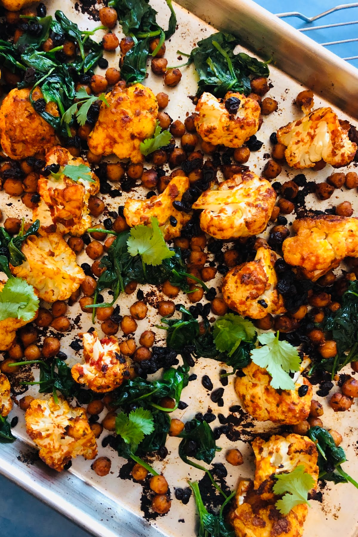 sheet pan with roasted cauliflower, chickpeas and spinach with harissa