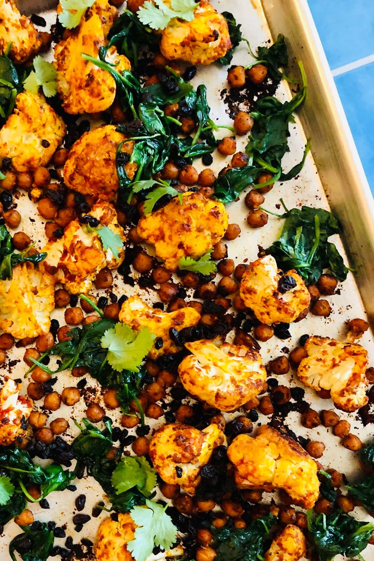 sheet pan with roasted cauliflower, chickpeas and spinach with harissa