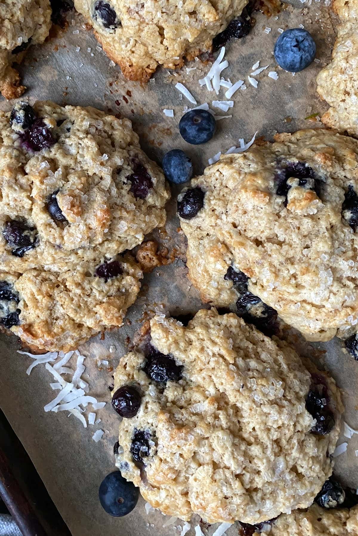 Drop scone recipe for big scones with blueberries on parchment paper.