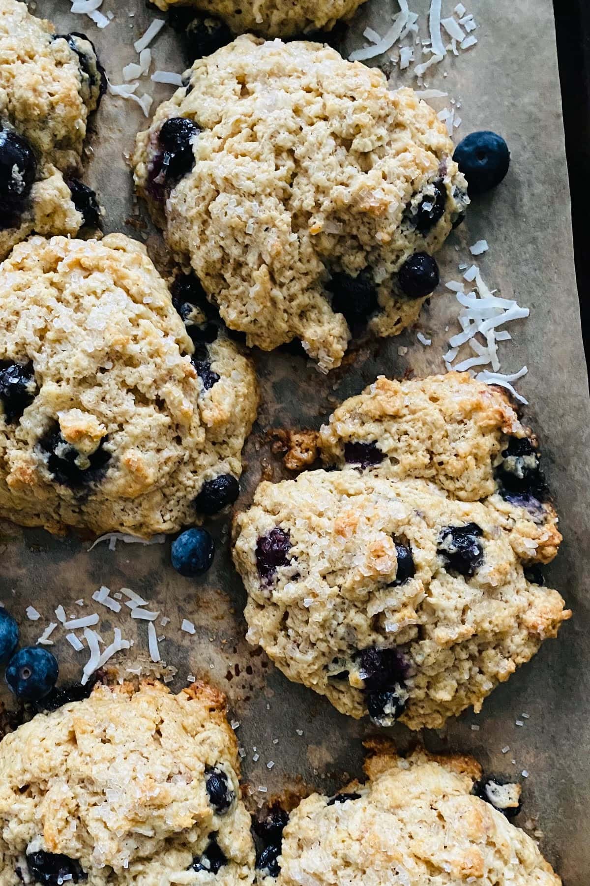 Craggy, tender buttery blueberry scones on a baking sheet.